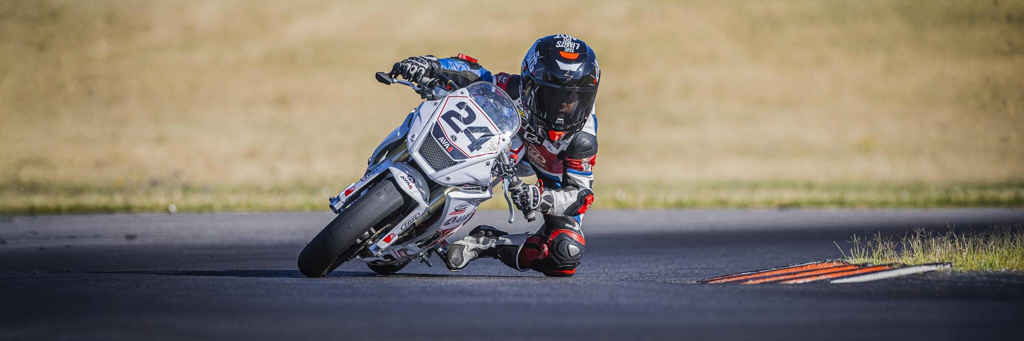 Pilote Mini OGP n°24 genou au sol en virage extrême sur le circuit de Muret, reportage moto par Frantz Meyers photographe sportif à Castres.